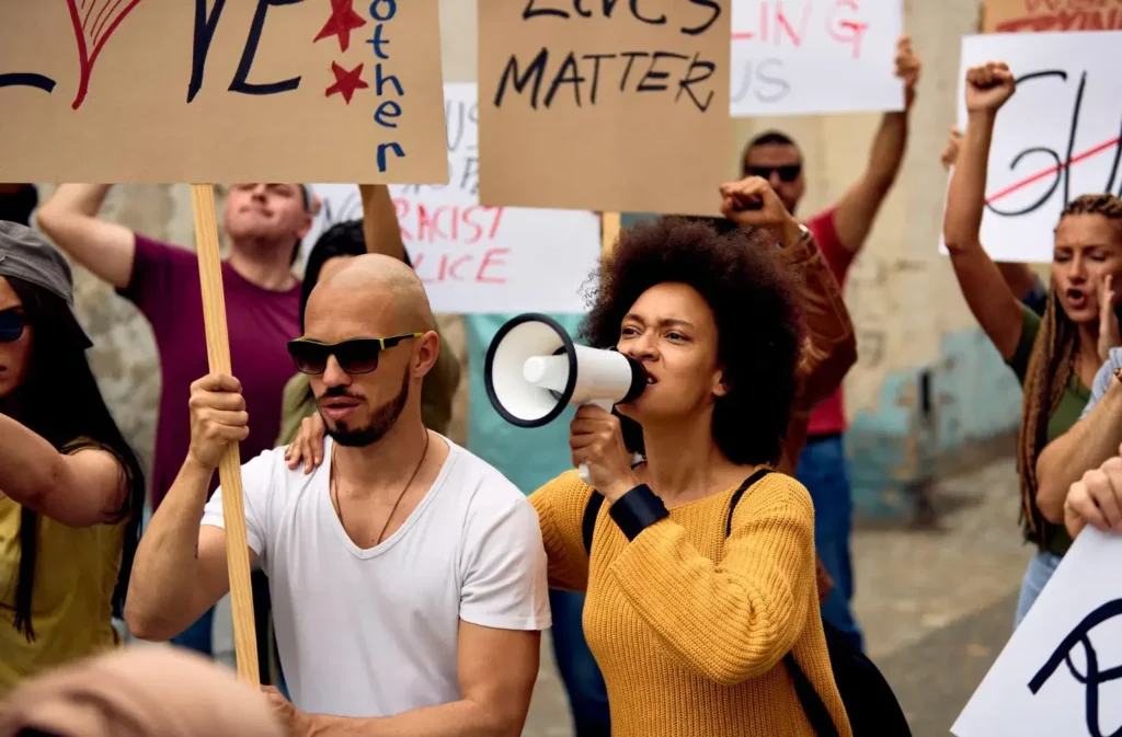 A serene urban landscape bathed in warm, golden-hour lighting. In the foreground, a vibrant mural depicts a diverse group of figures, their raised fists and determined expressions symbolizing the power of grassroots social justice movements. In the middle ground, a network of intersecting data visualizations and infographics hover above the cityscape, showcasing the tangible impact and measurable success of these activists' tireless efforts. The background is a hazy skyline, hinting at the far-reaching scope of their work. The overall scene conveys a sense of hope, progress, and the transformative potential of data-driven advocacy. Human rights activists and their work